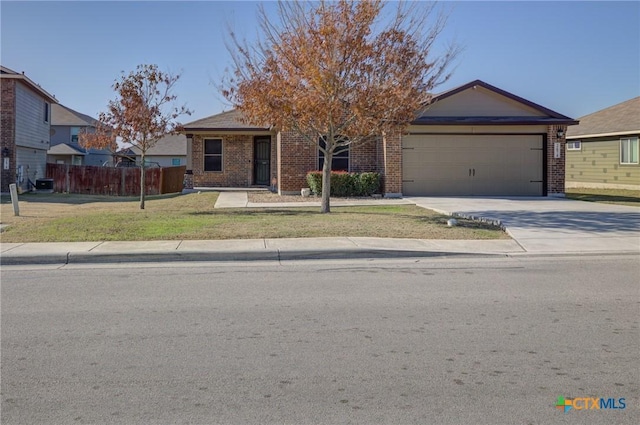 view of front of house featuring a front lawn, driveway, fence, a garage, and brick siding