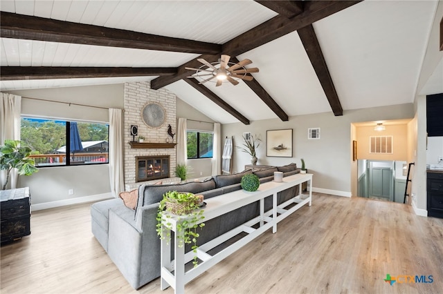 living room with a fireplace, ceiling fan, light hardwood / wood-style flooring, and lofted ceiling with beams