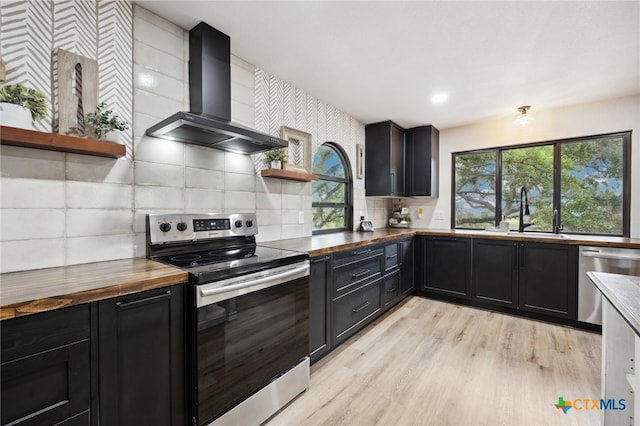 30817 Wildcat Dr, Bulverde, TX 78163 - kitchen with stainless steel appliances, wall chimney range hood, open shelves, wood counters, and dark cabinets
