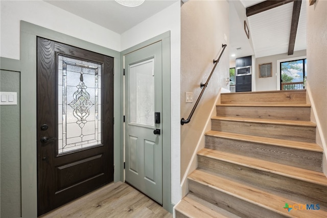 entrance foyer with beamed ceiling and light wood-type flooring