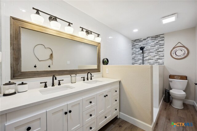 30817 Wildcat Dr, Bulverde, TX 78163 - full bathroom with wood finished floors, double vanity, a tile shower, and recessed lighting