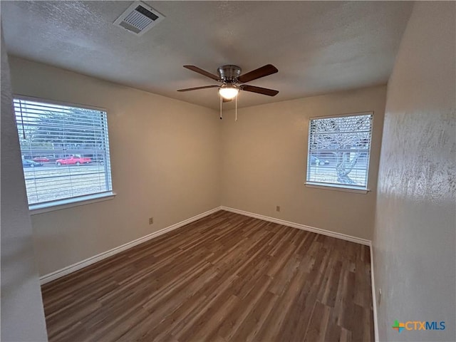 spare room with ceiling fan, dark hardwood / wood-style flooring, and a textured ceiling