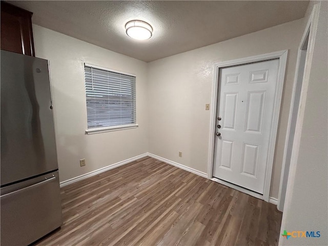 foyer entrance with a textured ceiling and hardwood / wood-style flooring