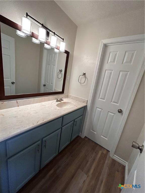 bathroom with a textured ceiling, vanity, and hardwood / wood-style flooring