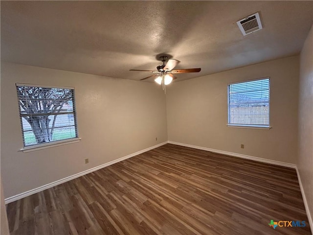 spare room featuring ceiling fan, dark hardwood / wood-style flooring, and a textured ceiling