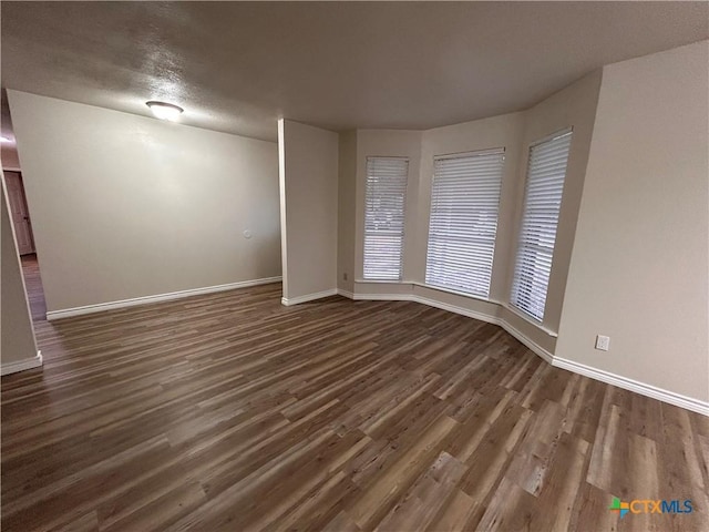 spare room with dark hardwood / wood-style floors