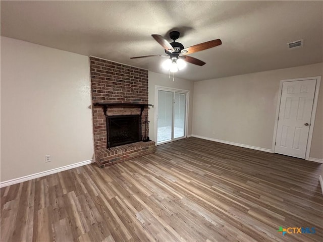 unfurnished living room featuring ceiling fan, a fireplace, a textured ceiling, and hardwood / wood-style flooring