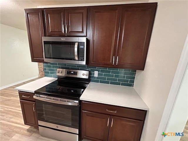 kitchen with decorative backsplash, dark brown cabinets, light hardwood / wood-style floors, and appliances with stainless steel finishes