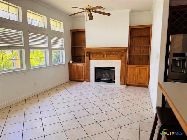 3900 Chisholm Trl, Salado, TX 76571 - unfurnished living room featuring ornamental molding, a ceiling fan, a tiled fireplace, light tile patterned floors, and baseboards