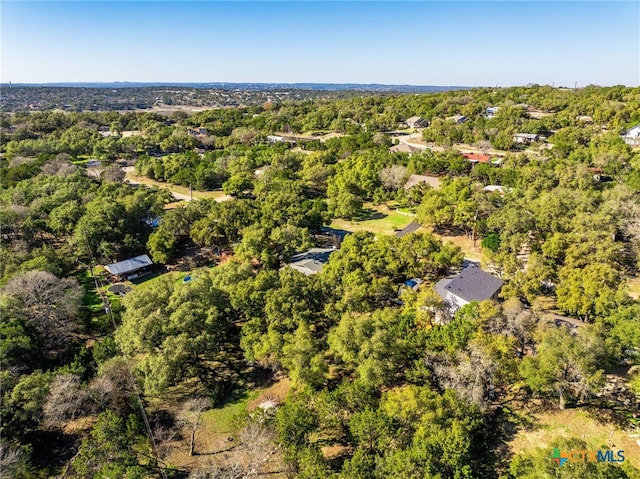 drone / aerial view with a wooded view