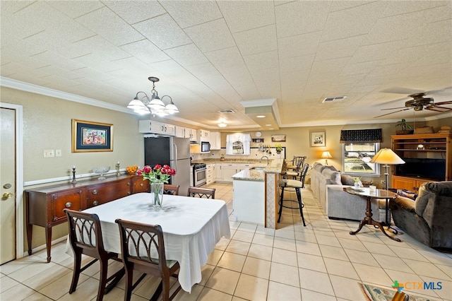 dining room with light tile patterned floors, visible vents, crown molding, and ceiling fan with notable chandelier