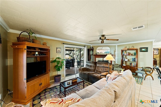 living room featuring ornamental molding, visible vents, ceiling fan, and light tile patterned floors