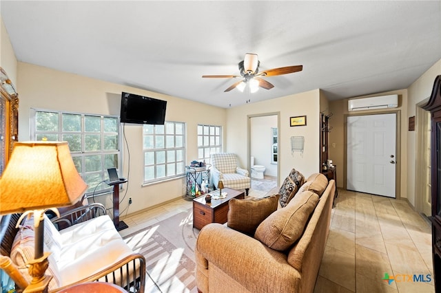 living area featuring a wall unit AC, ceiling fan, and light tile patterned flooring