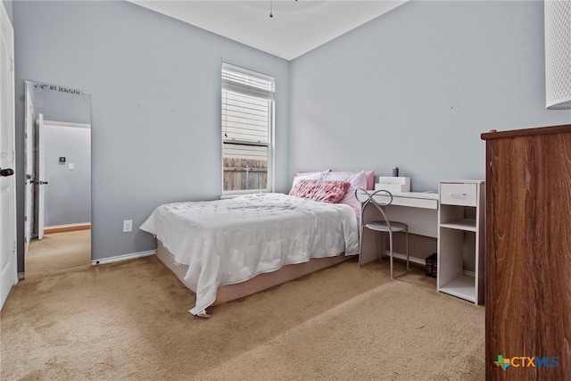 bedroom with baseboards, carpet floors, and lofted ceiling