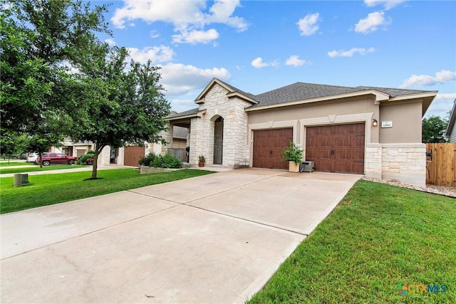 view of front of house with stone siding, a garage, concrete driveway, and a front yard