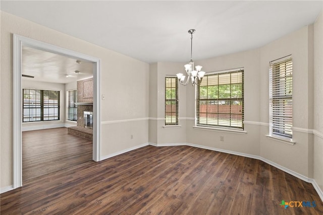 601 Pondview Dr, Killeen, TX 76542 - unfurnished dining area with dark wood-style floors, a chandelier, healthy amount of natural light, and a brick fireplace