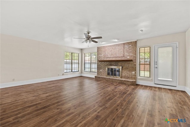 601 Pondview Dr, Killeen, TX 76542 - unfurnished living room featuring dark wood-style floors, healthy amount of natural light, ceiling fan, and a fireplace