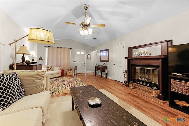 living room with light wood-type flooring, ceiling fan, and vaulted ceiling