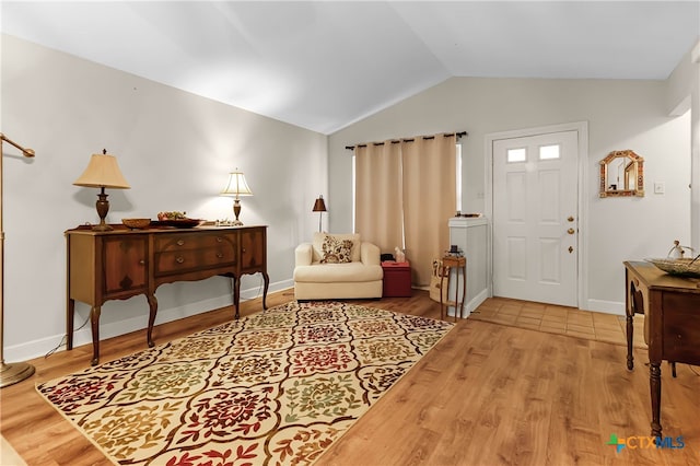 entryway with wood-type flooring and vaulted ceiling