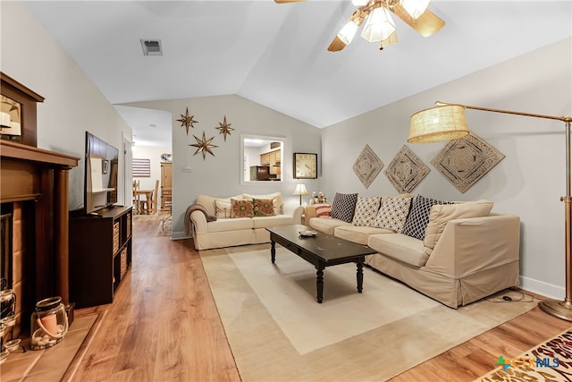 living room with ceiling fan, light wood-type flooring, and lofted ceiling