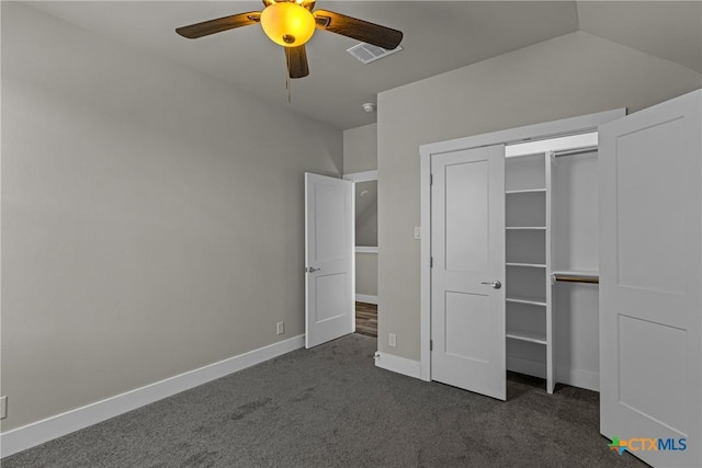 unfurnished bedroom with a closet, ceiling fan, dark colored carpet, and vaulted ceiling