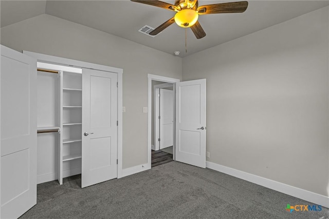 unfurnished bedroom with a closet, ceiling fan, dark carpet, and lofted ceiling