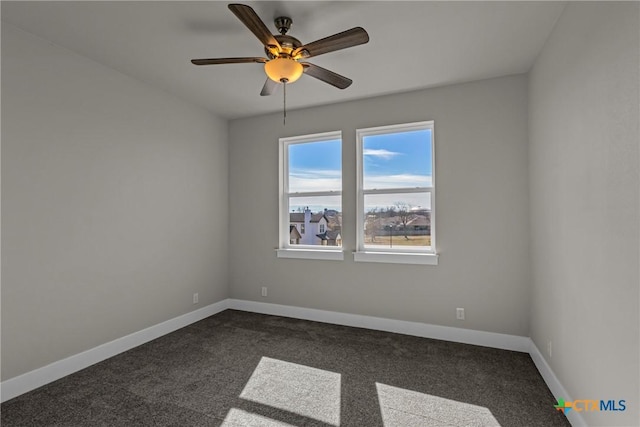 empty room featuring ceiling fan and dark carpet