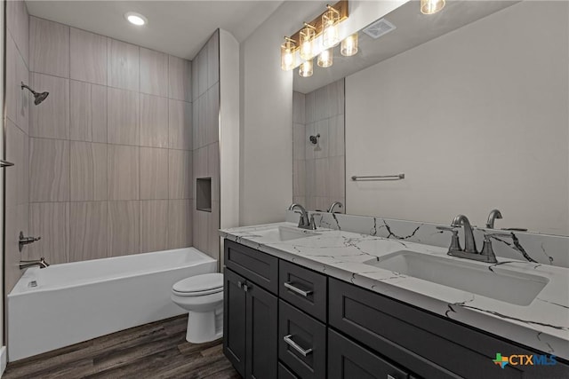 full bathroom with vanity, toilet, tiled shower / bath, and wood-type flooring