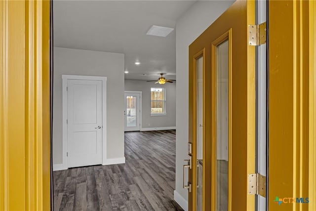 unfurnished living room featuring ceiling fan and dark wood-type flooring