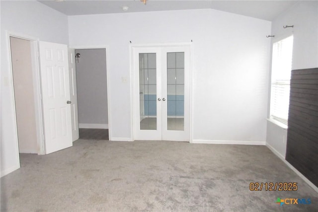 unfurnished room featuring light colored carpet, baseboards, vaulted ceiling, and french doors