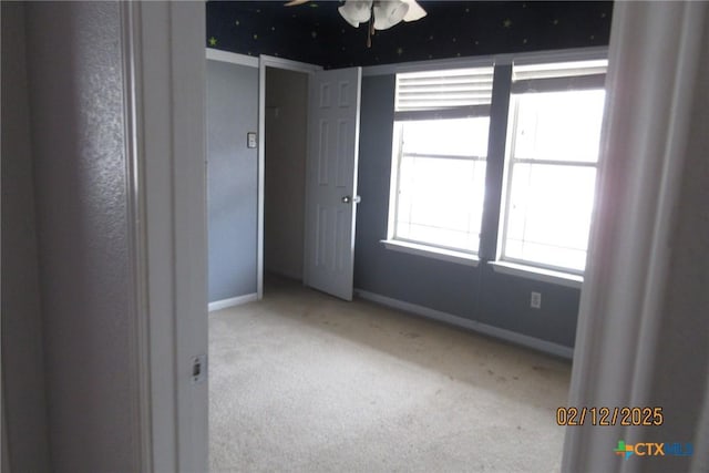 unfurnished room with light carpet and baseboards