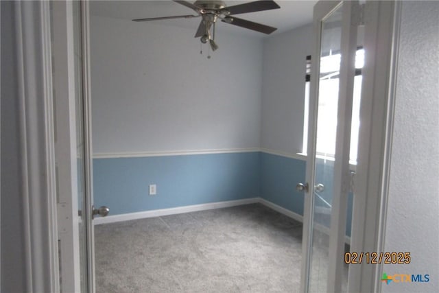 carpeted spare room with ceiling fan, baseboards, and french doors