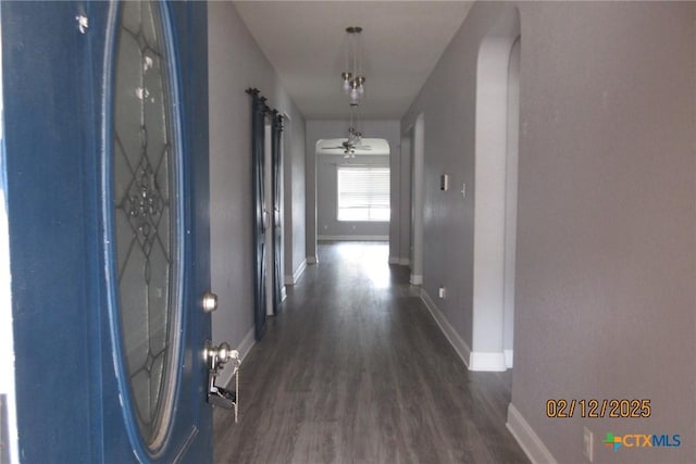 hall with dark wood finished floors and baseboards