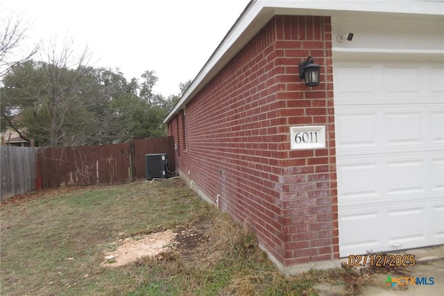 view of home's exterior with a garage, fence, cooling unit, and brick siding