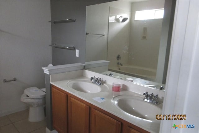 bathroom featuring double vanity, tile patterned flooring, a sink, and toilet