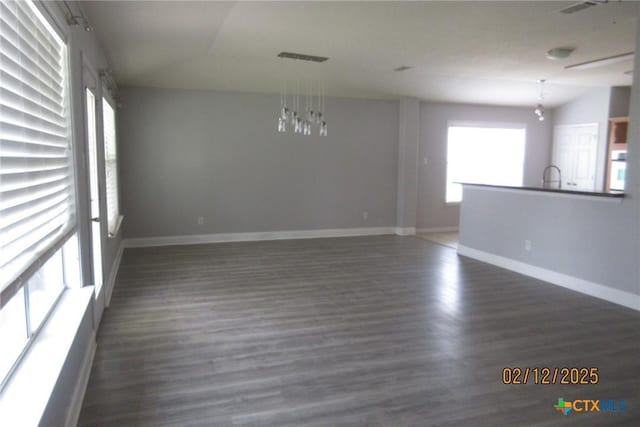 spare room with dark wood-style flooring and baseboards