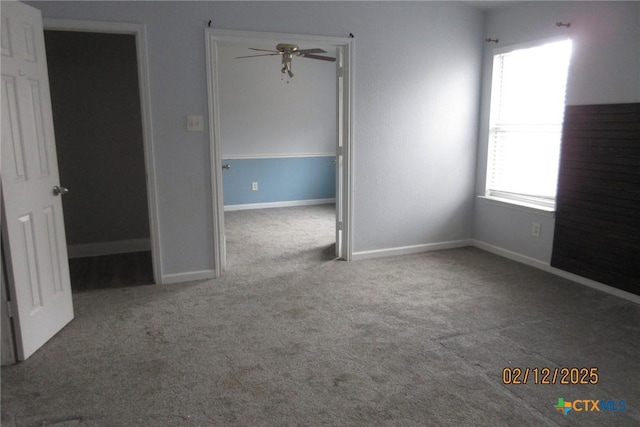 interior space with ceiling fan, baseboards, and carpet flooring