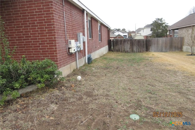 view of property exterior with brick siding and fence