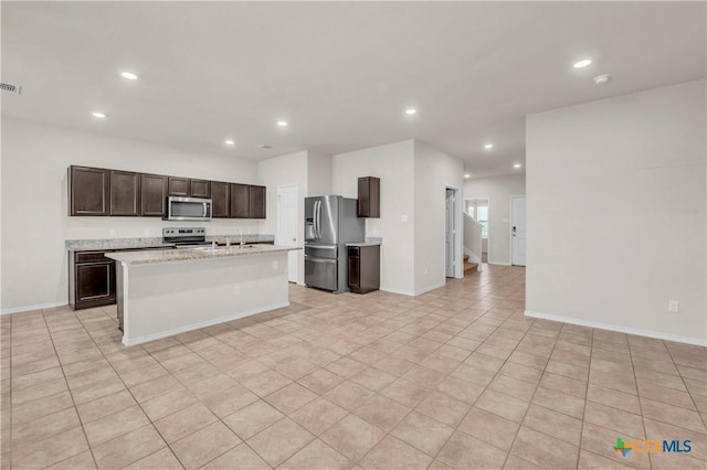6106 Amelia Earhart Blvd, Killeen, TX 76543 - kitchen with appliances with stainless steel finishes, recessed lighting, dark brown cabinets, a kitchen island with sink, and baseboards