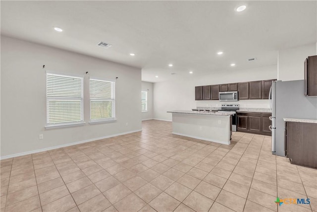 6106 Amelia Earhart Blvd, Killeen, TX 76543 - kitchen featuring stainless steel appliances, open floor plan, dark brown cabinetry, recessed lighting, and a kitchen island with sink