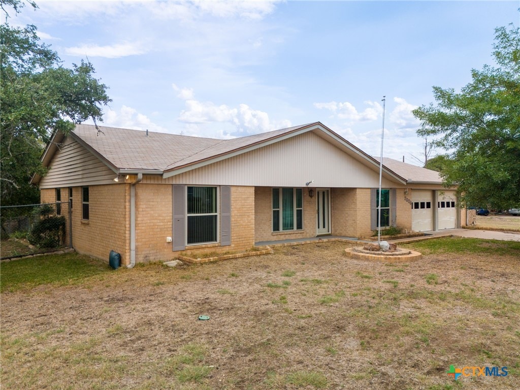 single story home with a garage and a front yard