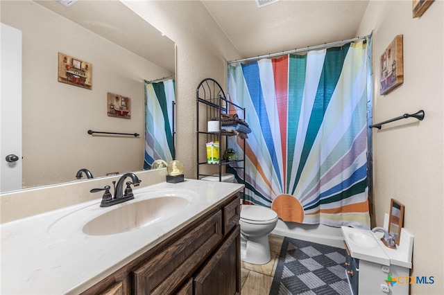 full bathroom featuring vanity, shower / bath combination with curtain, and toilet