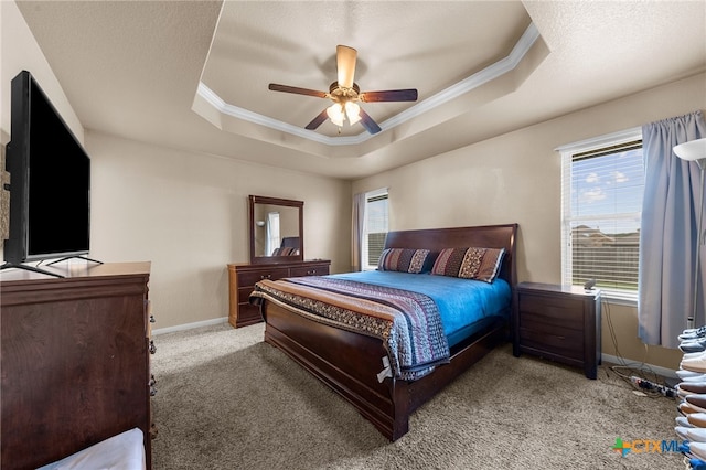 bedroom with ornamental molding, a textured ceiling, light carpet, a raised ceiling, and ceiling fan