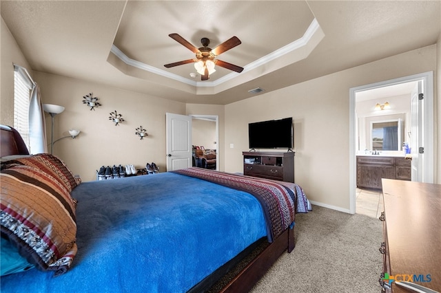 bedroom featuring carpet, ceiling fan, a raised ceiling, and connected bathroom