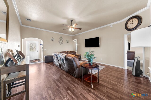 living room featuring dark wood-type flooring, ceiling fan, and crown molding