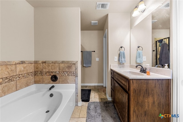 bathroom featuring vanity, tile patterned flooring, and a washtub