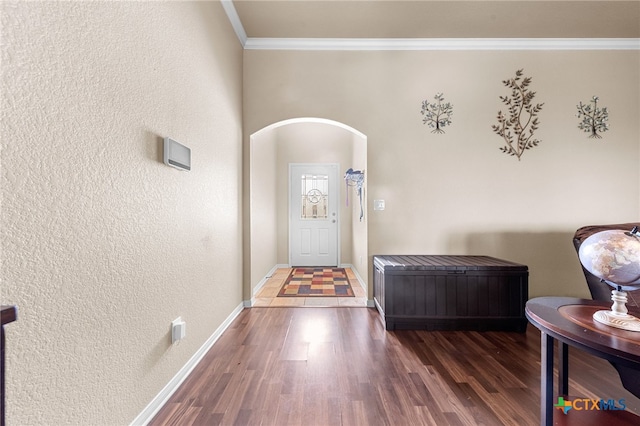 entryway with dark wood-type flooring and ornamental molding