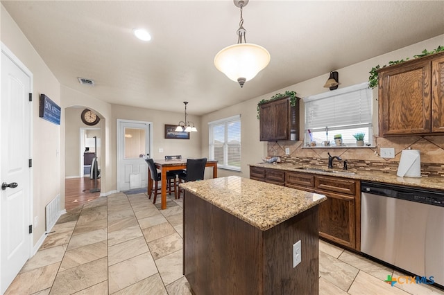 kitchen with dishwasher, plenty of natural light, pendant lighting, and a kitchen island