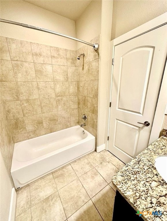 bathroom featuring tiled shower / bath, vanity, and tile patterned flooring