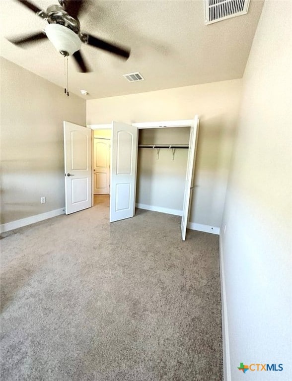 unfurnished bedroom with ceiling fan, a textured ceiling, a closet, and carpet floors